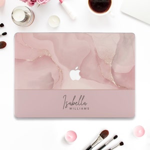 May include: A pink and gold laptop skin with a marble design and the name "Isabella Williams" printed on the bottom.