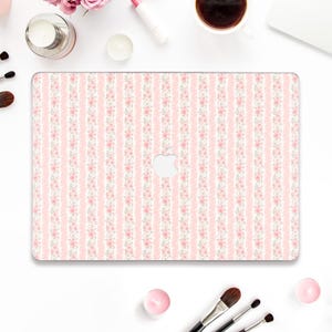 May include: A laptop case with a pink and white floral stripe pattern. The case features a repeating design of pink flowers and green leaves on a white background, with pink vertical stripes. The Apple logo is visible.