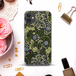 May include: A clear phone case with a floral design. The design features green leaves, blue flowers, and a brown background.