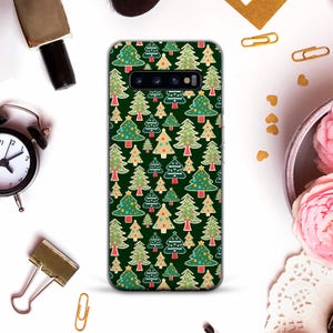 May include: A green phone case with a repeating pattern of Christmas trees. The trees are decorated with colorful ornaments and lights.