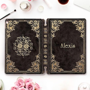 May include: Black iPad case with a vintage book design. The case features gold floral embellishments and the name "Alexis" in gold lettering. The case is open, revealing the interior and spine, with a detailed, antique aesthetic.