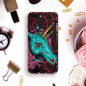 May include: A phone case with a graphic of a blue and green unicorn with a gold horn, surrounded by thorns and vines. The background is black.