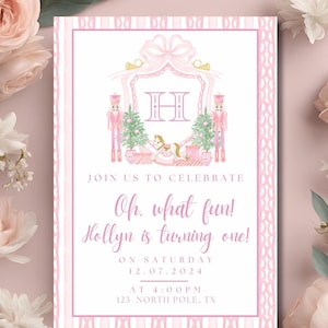 May include: Pink and white invitation with a watercolor illustration of a nutcracker, a rocking horse, and a Christmas tree. The invitation reads "Join us to celebrate Oh, what fun! Hollyn is turning one! On Saturday 12.07.2024 at 4:00PM 123 North Pole, TX"