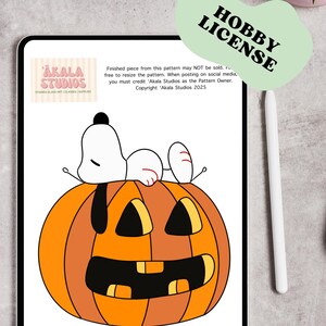 Op de afbeelding: Een digitale tablet toont een glas-in-loodpatroon met een witte cartoonhond die op een grote oranje pompoen met zwarte gelaatstrekken ligt. Het scherm bevat de tekst Akala Studios en een Hobby License label.