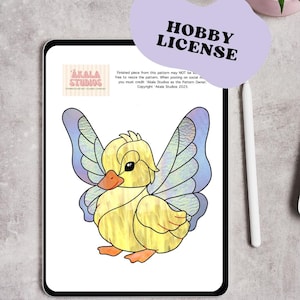 May include: A digital image of a yellow duckling with fairy wings, displayed on a tablet. The duckling has an orange beak and feet, with blue and purple wings. The image includes the text "HOBBY LICENSE" and "AKALA STUDIOS".