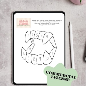 May include: A digital tablet displays a black and white stained glass pattern of a set of teeth, numbered 1-14. The tablet also shows the text "AKALA STUDIOS" and "COMMERCIAL LICENSE". A white stylus and a small potted plant are visible.
