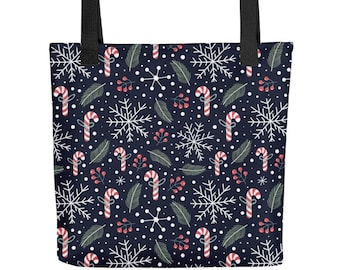 May include: A dark navy blue tote bag featuring a repeating holiday pattern of white snowflakes, red and white striped candy canes, green pine needles, and small red berries. The bag has two sturdy black fabric handles attached at the top.