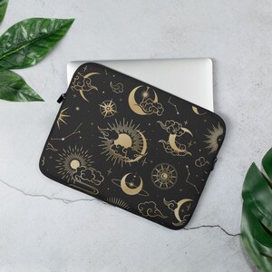 May include: Black laptop sleeve with a gold celestial pattern featuring moons, stars, suns, and clouds.