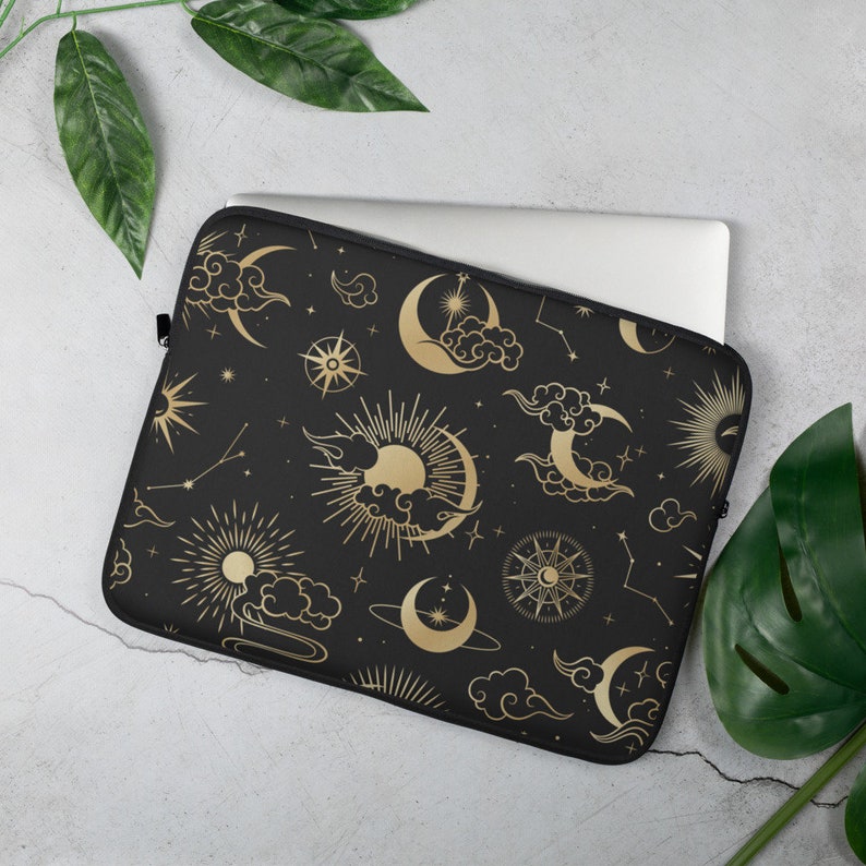 May include: Black laptop sleeve with a gold celestial pattern featuring moons, stars, clouds, and suns.