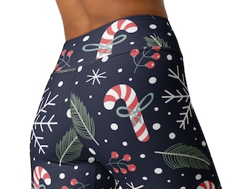 May include: High-waisted leggings in a dark navy blue color featuring a festive holiday pattern. The print includes red and white striped candy canes tied with light green bows, white snowflakes, green pine needles, and small red berry clusters.