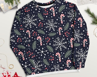 May include: A dark navy blue long-sleeve sweatshirt featuring a repeating holiday pattern of white snowflakes, red and white striped candy canes, green pine needles, and small red berries scattered across the fabric with white polka dots.