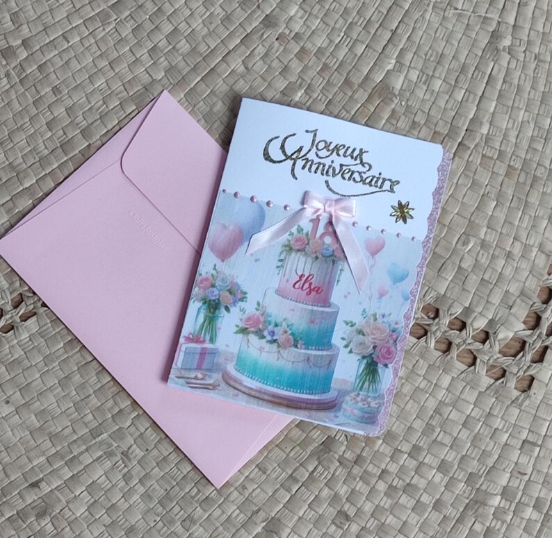 Carte anniversaire 18 ans personnalisée fille adolescente rose. Un gros gateau surmonté du chiffre 18 et sur le gâteau inscrit le prénom de la fille. Joyeux anniversaire est écrit en doré