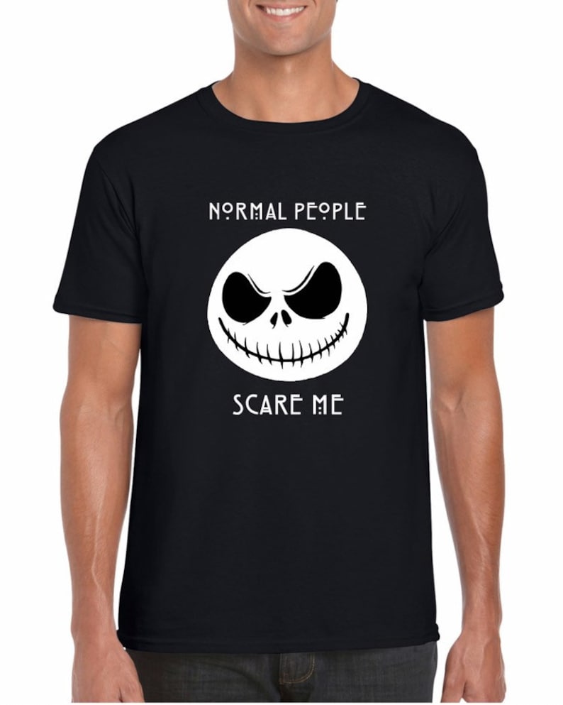 May include: Black t-shirt with a white graphic of Jack Skellington's face from The Nightmare Before Christmas. The text "NORMAL PEOPLE SCARY ME" is printed above the graphic.