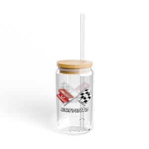 May include: A clear glass tumbler with a wooden lid and a clear straw. The tumbler features a graphic of crossed racing flags in red and black, with the word "Corvette" in silver lettering.