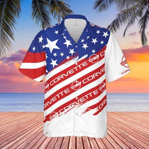 May include: A short-sleeve button-down shirt featuring a patriotic design with a blue field of white stars on the upper portion and diagonal red and white stripes across the body. The word Corvette and the circular logo are printed repeatedly.