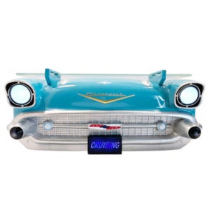 May include: A turquoise blue 1957 Chevrolet car shaped wall shelf with a glass top and a chrome grill. The shelf has a license plate that reads "CRUISING".
