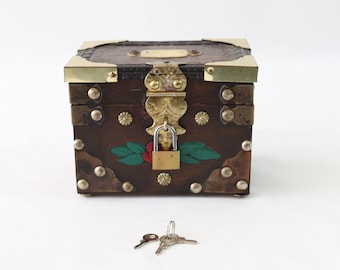 May include: A wooden box with a brass latch and hinges, decorated with painted flowers and leaves. The box is secured with a padlock and comes with two keys.