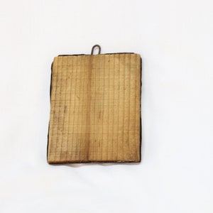 May include: A wooden plaque with a black frame and a metal hook on the top.