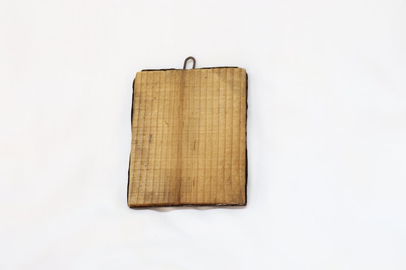 May include: A wooden plaque with a black frame and a metal hook on the top.
