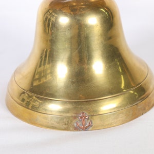 May include: A brass bell with an anchor engraved on the bottom.