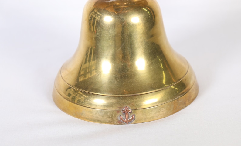 May include: A brass bell with an anchor engraved on the bottom.