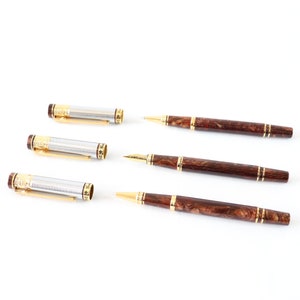 May include: Four pens, two with silver and gold accents and two with brown wood-like accents. The pens with silver and gold accents are disassembled, showing the inner workings of the pen.