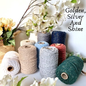 May include: Assortment of cotton rope in various colours, including white, beige, light blue, grey, red, dark blue, and green. Some of the ropes have a gold or silver metallic thread woven into the cotton.