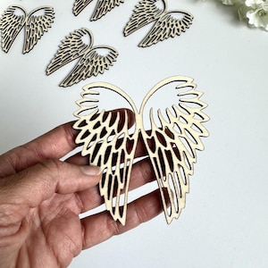 Op de afbeelding: Een set van zes houten engelenvleugels met een delicaat, ingewikkeld ontwerp. De vleugels zijn onbewerkt en klaar om te worden geschilderd of gebeitst.