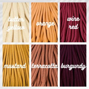 May include: A color palette featuring six different shades of fabric. The colors include butter yellow, orange, wine red, mustard, terracotta, and burgundy. Each color is labeled with its name in a cursive font.