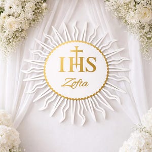 Può includere: Decorazione murale religiosa bianca e oro con la scritta "IHS" e "Zofia" in oro. Il disegno è circondato da un motivo a raggi di sole e fiori bianchi.