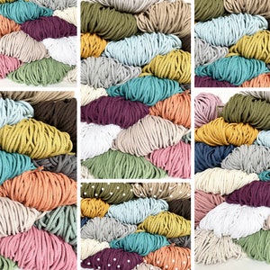 May include: A collection of colorful macrame cord in various shades, including pink, green, yellow, blue, and purple. The cords are arranged in a visually appealing pattern, showcasing the diverse color palette and textures of the materials.