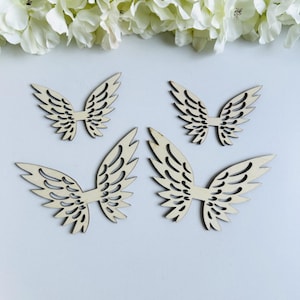 Op de afbeelding: Vier houten engelenvleugels met een delicaat, ingewikkeld ontwerp. De vleugels zijn uit hout gesneden en hebben een natuurlijke, lichtbruine kleur.