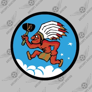 May include: A blue and white circular patch with a cartoon image of a Native American man running with a tomahawk in his hand. The man is wearing a feathered headdress and a loincloth. The background is a blue sky with white clouds and stars.