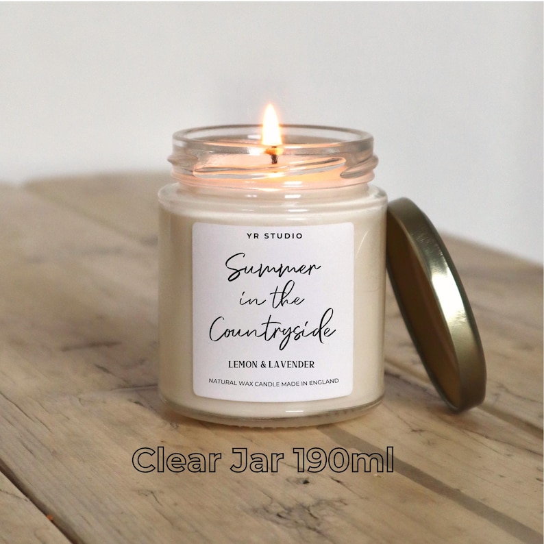May include: A clear glass jar candle with a white label that reads "YR STUDIO Summer in the Countryside Lemon & Lavender Natural Wax Candle Made in England". The candle is 190 ml and has a gold lid.