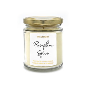 May include: A glass jar candle with a gold lid. The label reads "YR Studio Pumpkin Spice Scented Soy Wax Candle Hand-Poured in Somerset."