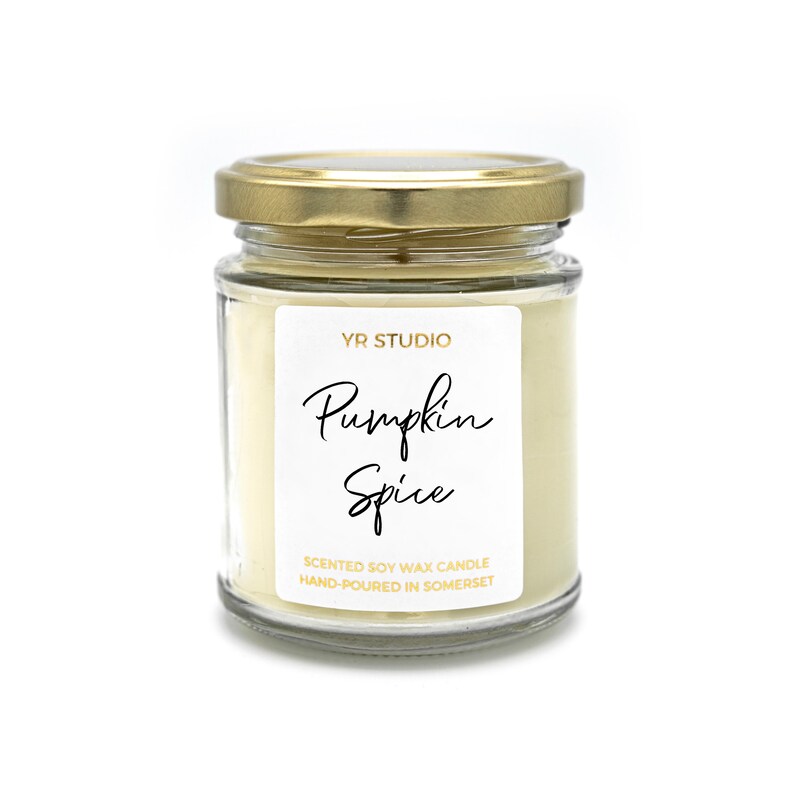 May include: A glass jar candle with a gold lid. The label reads "YR Studio Pumpkin Spice Scented Soy Wax Candle Hand-Poured in Somerset."
