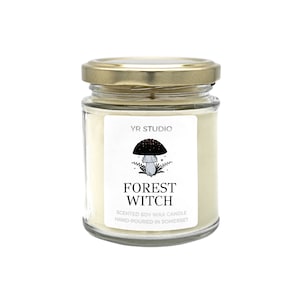 May include: A glass jar candle with a gold lid. The label features a black mushroom illustration and the words "Forest Witch". The candle is scented soy wax and hand-poured in Somerset.