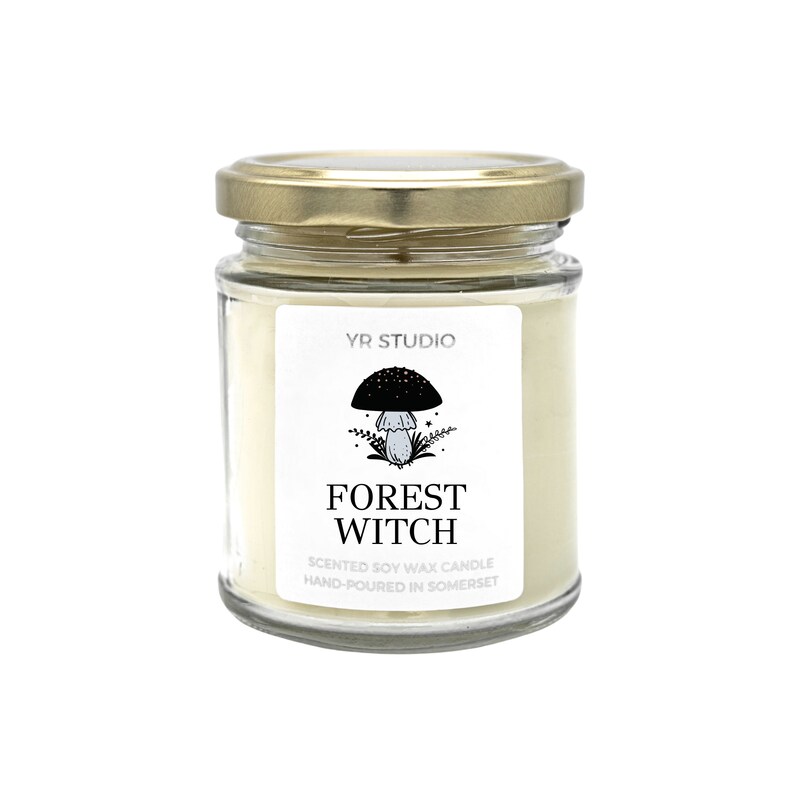 May include: A glass jar candle with a gold lid. The label features a black mushroom illustration and the words "Forest Witch". The candle is scented soy wax and hand-poured in Somerset.