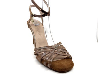 Op de afbeelding: Bruine suède sandalen met hak, een gekruist bandontwerp en een gouden accent. De sandalen hebben een gesloten teen en een enkelband met een gespsluiting. De merknaam "LUIS VIENTO" staat gedrukt op de binnenzool.