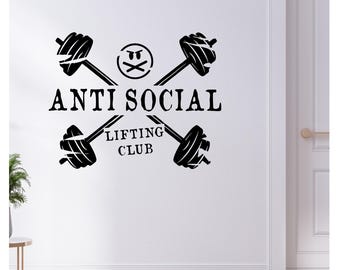 May include: Black wall decal featuring the words "ANTI SOCIAL LIFTING CLUB" with a barbell design and a crossed-out face symbol. The design is centered on a white wall.