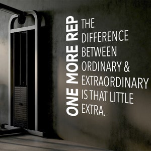May include: A motivational quote on a gray wall in a gym setting: "One more rep is the difference between ordinary & extraordinary is that little extra."
