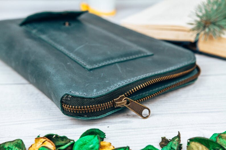May include: A teal leather zippered wallet with a flap pocket and a brass zipper pull.