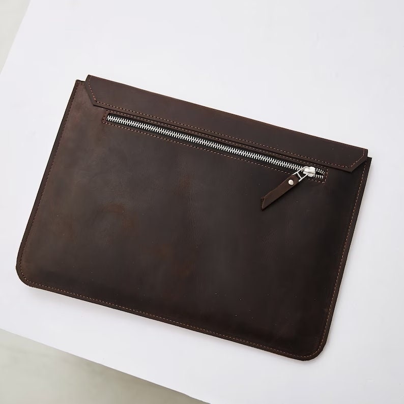 Puede incluir: Una funda para port&aacute;til de cuero marr&oacute;n con cierre de cremallera. La funda tiene un aspecto desgastado sutil y est&aacute; hecha de cuero de alta calidad.