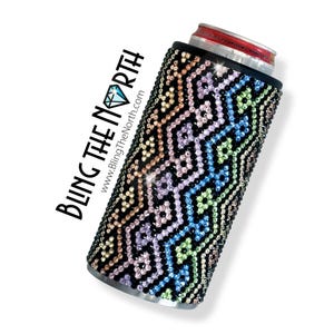 Peut inclure: Un refroidisseur de canette noir avec un motif géométrique coloré fait de strass. Le refroidisseur porte le texte "Bling The North" et le site Web "www.BlingTheNorth.com" imprimé dessus.