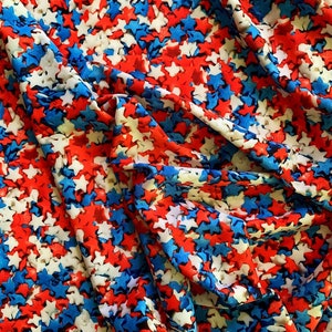 Puede incluir: Tela roja, blanca y azul con un patr&oacute;n de estrellas. La tela est&aacute; hecha de un material suave y el&aacute;stico, ideal para proyectos de manualidades.