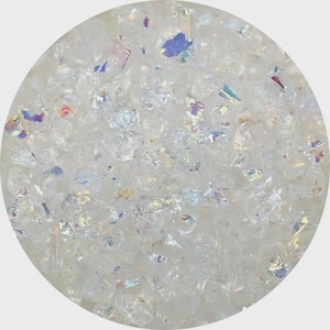 May include: Close-up of a collection of small, irregularly shaped, clear, and white crystals. The crystals have iridescent, rainbow-colored flashes throughout. The crystals are contained within a white circular shape.