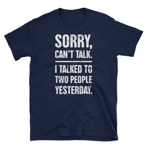 May include: Navy blue t-shirt with a white distressed graphic that reads "SORRY, CAN'T TALK. I TALKED TO TWO PEOPLE YESTERDAY."