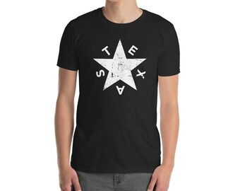 Op de afbeelding: Een zwart T-shirt met een witte, verweerde vijfpuntige ster en de letters "TEXAS" rond de ster.