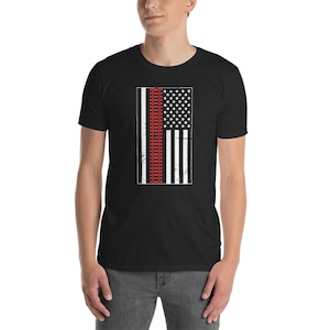 May include: A black t-shirt with a distressed American flag design featuring a red railway track in the centre.
