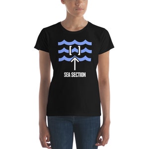 Puede incluir: Una camiseta negra para mujer con un gráfico blanco de una ola de mar con una flecha apuntando hacia arriba y el texto "SEA SECTION".